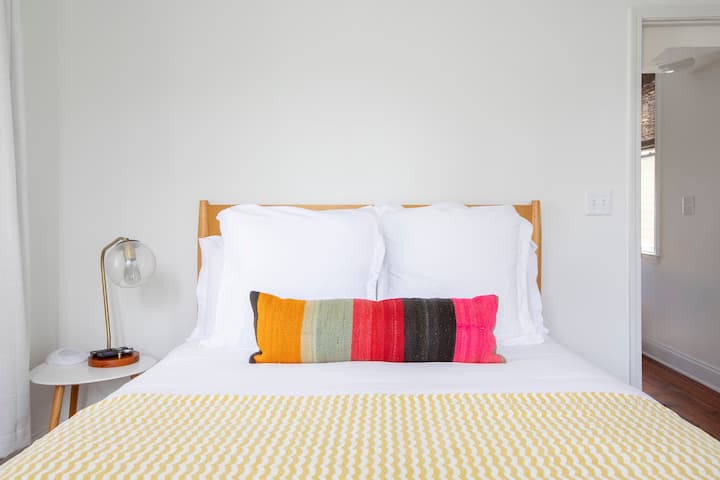 Spálňa na prízemí, televízor, zvukový prístroj a tmavé závesy.