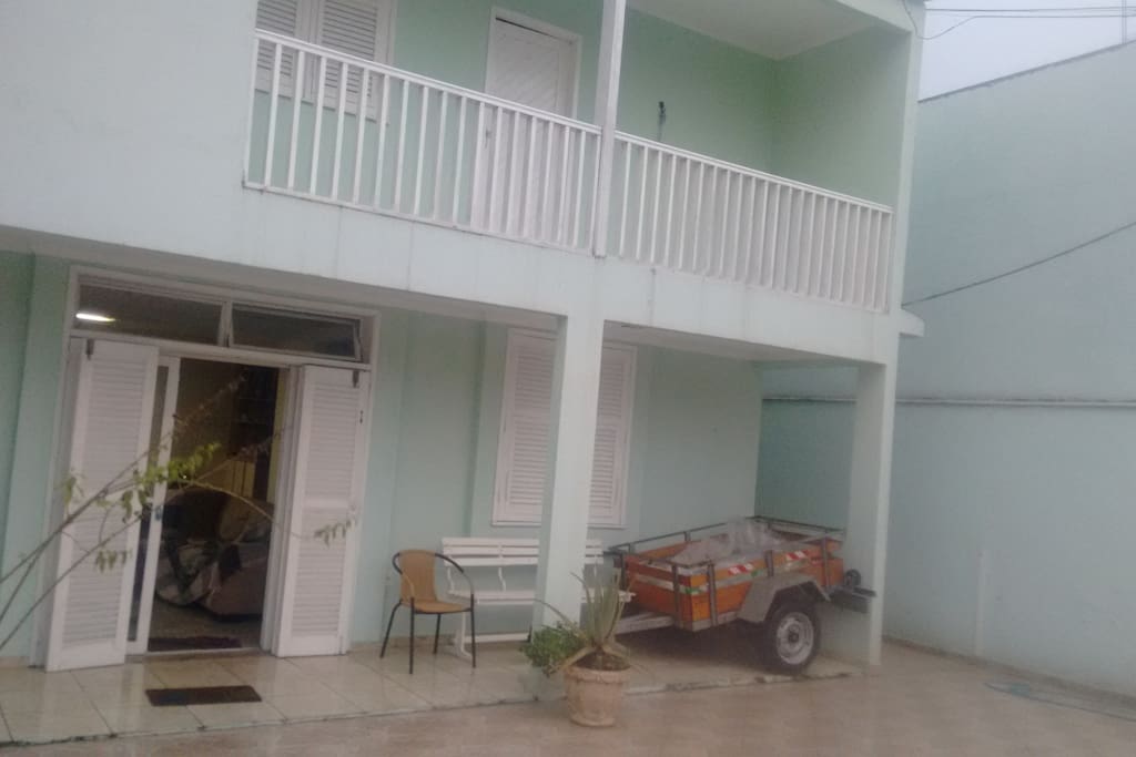 Parte frontal externa da casa, varanda e garagem.