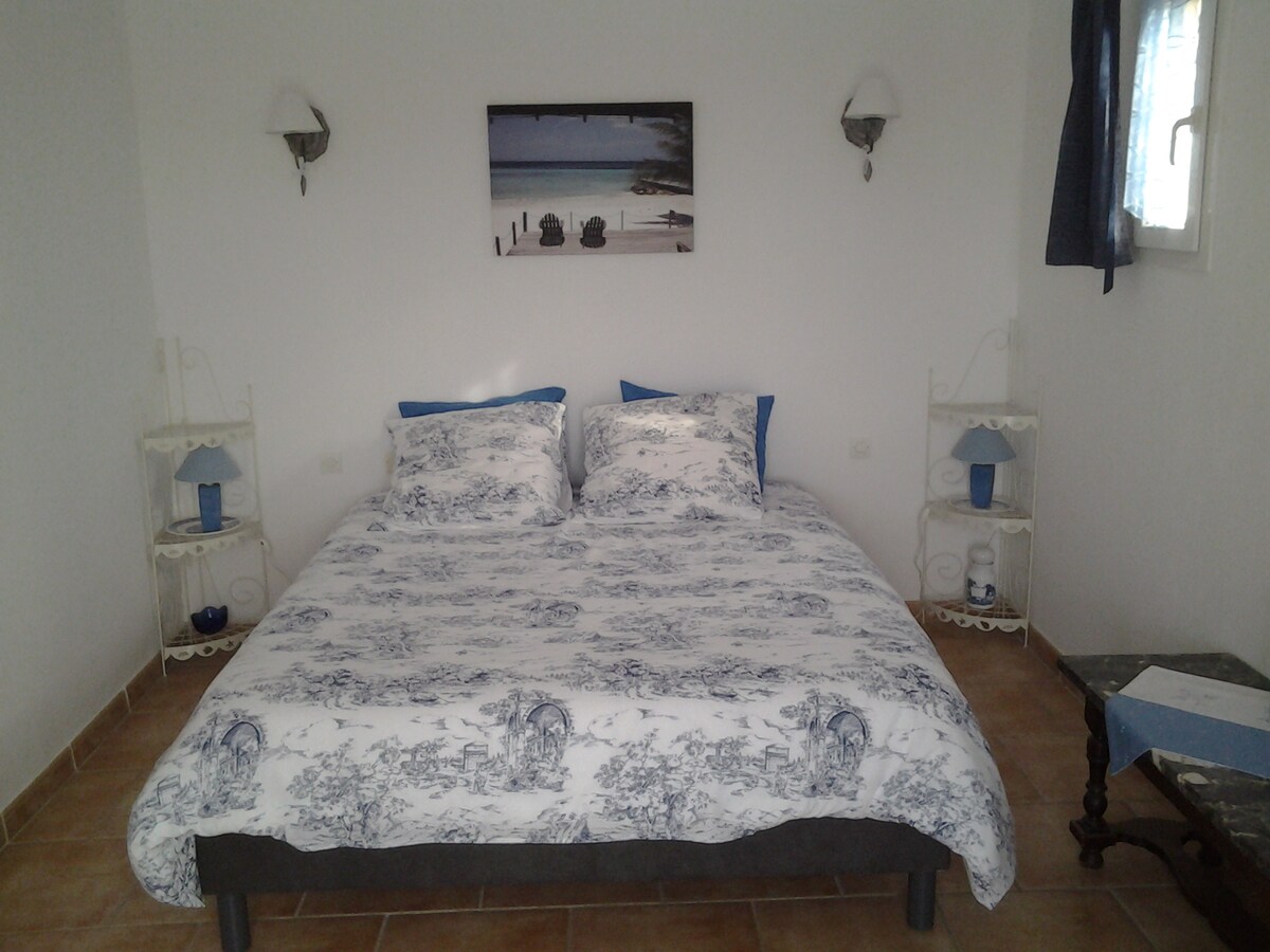 غرفة نوم في الطابق الأرضي مع أبواب إلى الشرفة