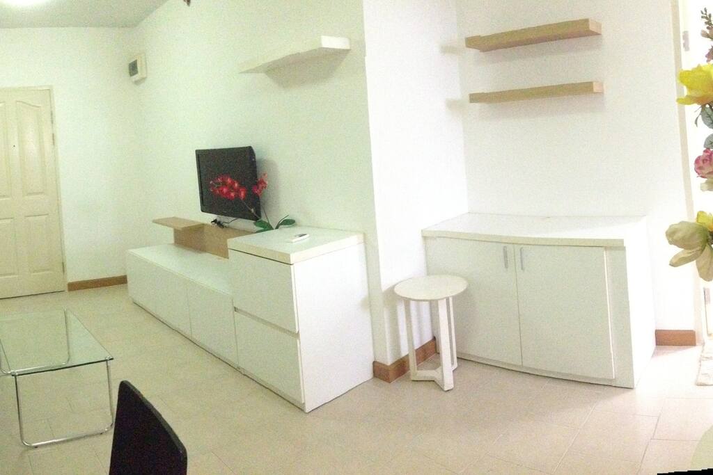 Spacious living room with comfortable couch, dining table, and LCD TV