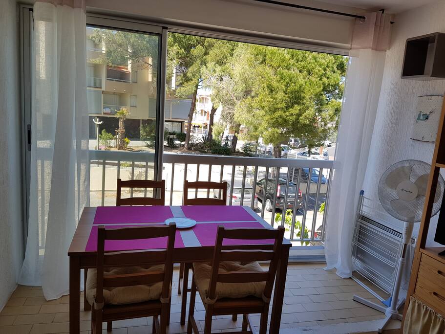 Coin repas avec baie vitrée qui s'ouvre au 3/4