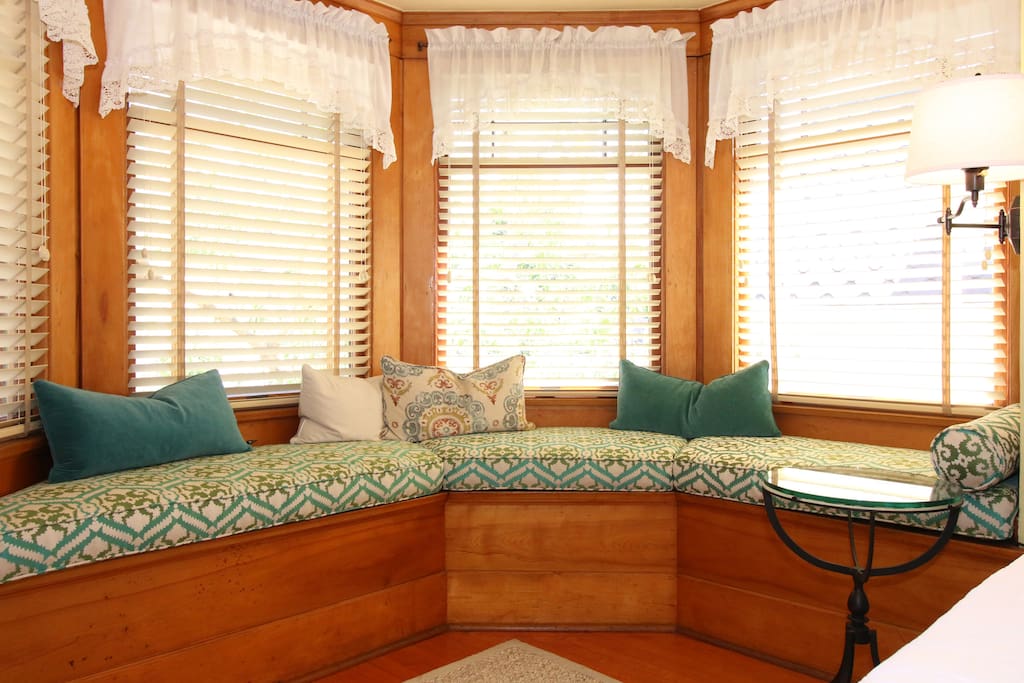 A beautiful window seat with lots of light streaming in through the windows