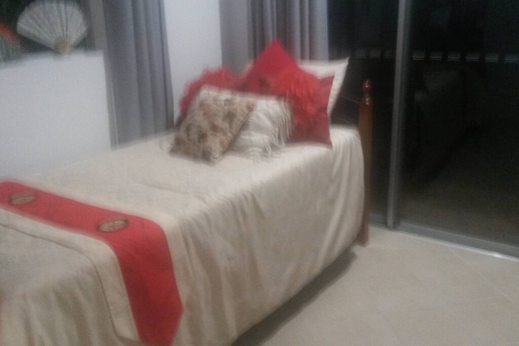 Single bedroom with sliding patio door. Built-in robe, ceiling fan. Tiled floor.