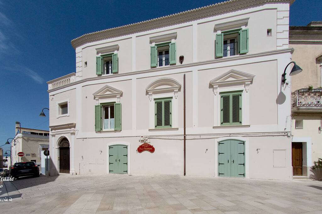 Nel centro storico di Miglionico, a due passi da Matera, si offre all’ospitalità dei viandanti, un’antica e nobile dimora, in cui l’armonia achitettonica e la cura dei dettagli rendono speciale anche la più semplice quotidianetà. La “Residenza delle Grazie”, incastonata tra storia e poesia, si scorge nella sua chiara ed elegante facciata sul sagrato della Chiesa Madre, abbracciata dai vicoli stretti ed antichi, che accompagnano il visitatore tra il castello medioevale e le case dipinte di bianco.
La nostra famiglia ha voluto condividere l’amore per la propria terra, aprendo la “Residenza delle Grazie” a quanti cercano luoghi suggestivi e confortevoli, alla scoperta di tradizioni, culture e paesaggi. Nel 2015 abbiamo ultimato la ristrutturazione dello storico edificio seicentesco, di circa seicento mq su due livelli; una parte utilizzata dalla nostra famiglia, l’altra destinata a struttura ricettiva.
Siamo riusciti a realizzare venti posti letto suddivisi in sei camere di ampia metratura, ognuna con il proprio bagno. La disponibilità di alcuni terrazzi e di ampi spazi comuni ampliano la possibilità di godere dei comfort e della tranquillità della casa. Cerchiamo di tradurre l’entusiasmo che ci ha spinti ad intraprendere quest’esperienza, nella massima cura verso gli ospiti che ci onoriamo di accogliere, affinchè possa essere garantita una buona permanenza e un’ottima qualità dei servizi per tutti.