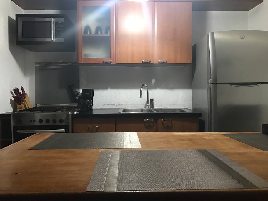 Cocina integral con barra,refrigerador,microondas,cafetera,estufa,horno.