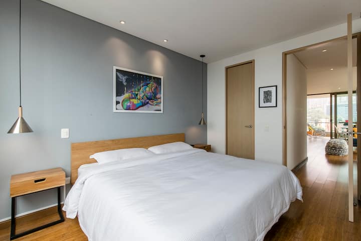 Suite principal con cama tamaño king, vista panorámica, TV de 55", vestidor y baño privado con su tocador.