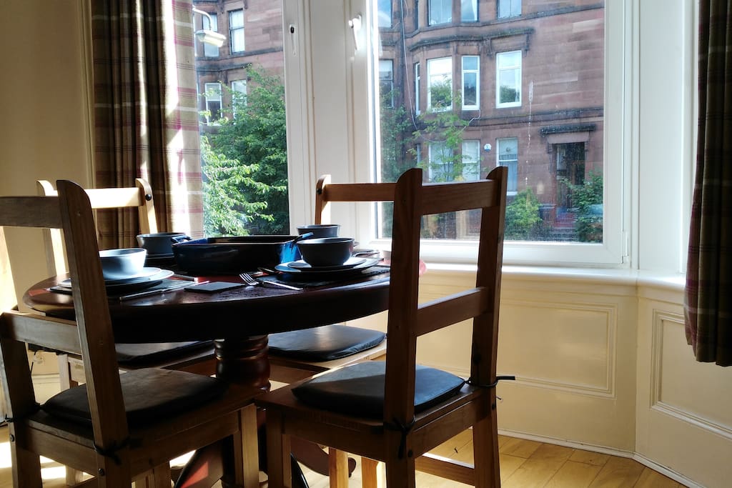 Dining area by large bay window that comfortably seats 4