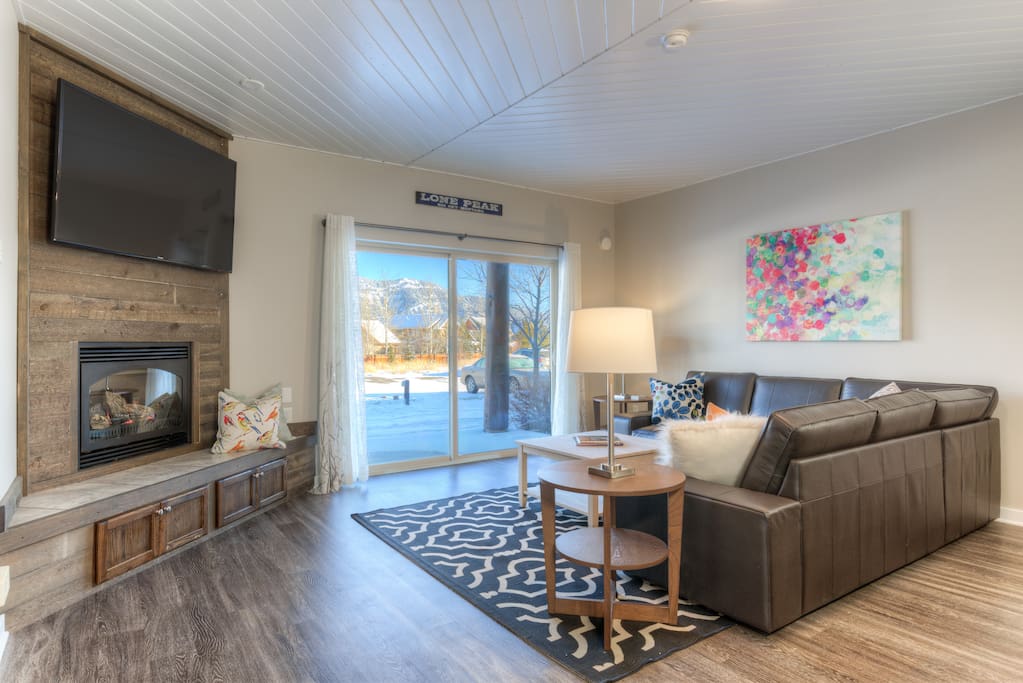 Living room with 60" TV and gas fireplace.