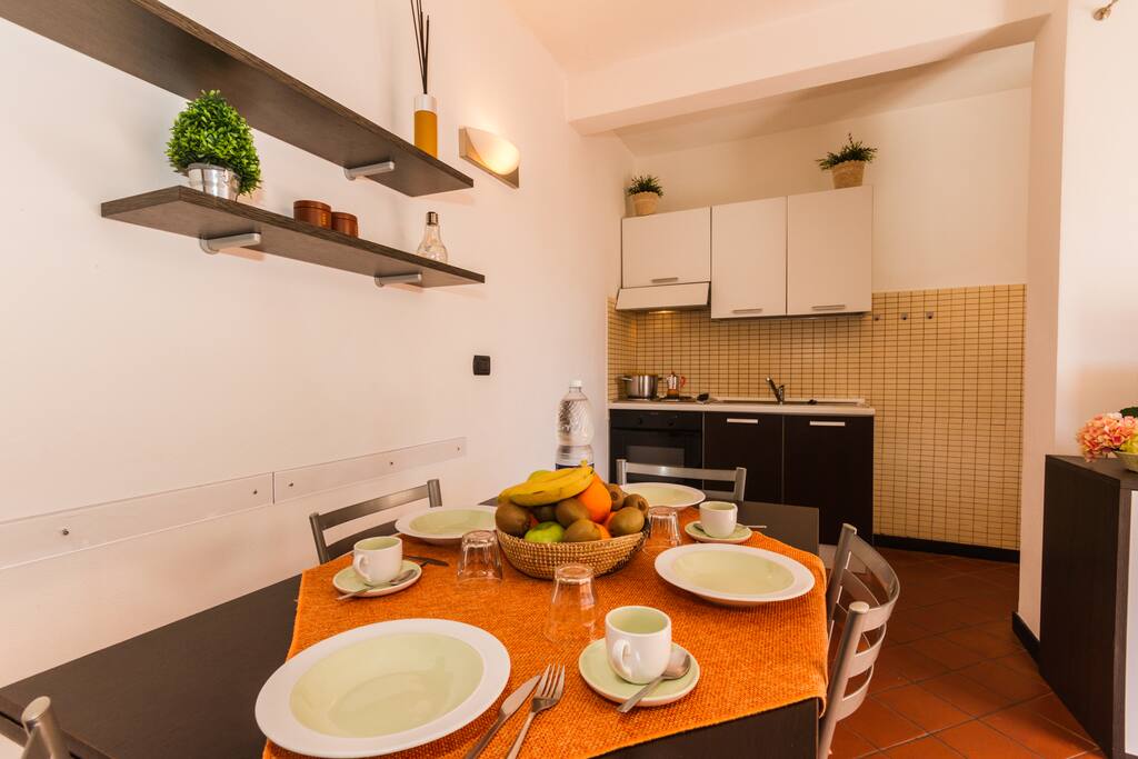 Kitchen and living room with flat screen TV dining table and sofa