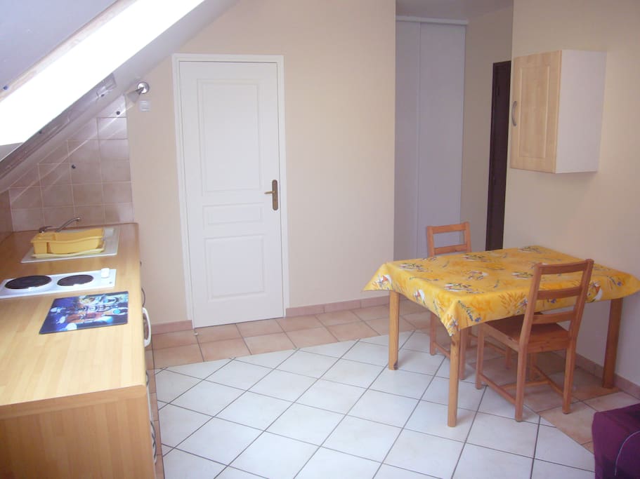 Table avec deux chaises et placard avec penderie