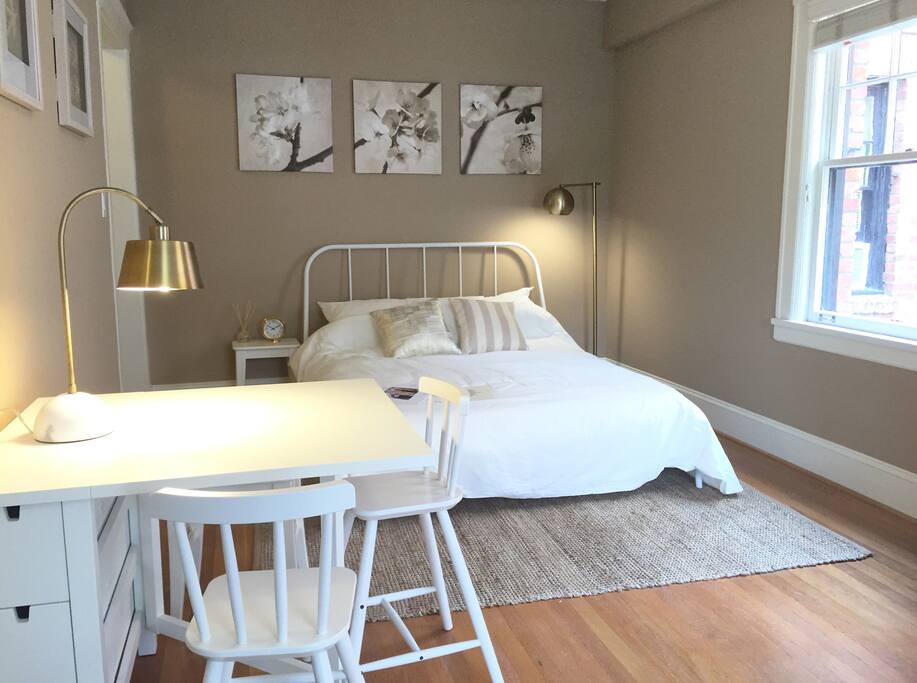 View of first half of studio: Featuring queen bed and dining/work table