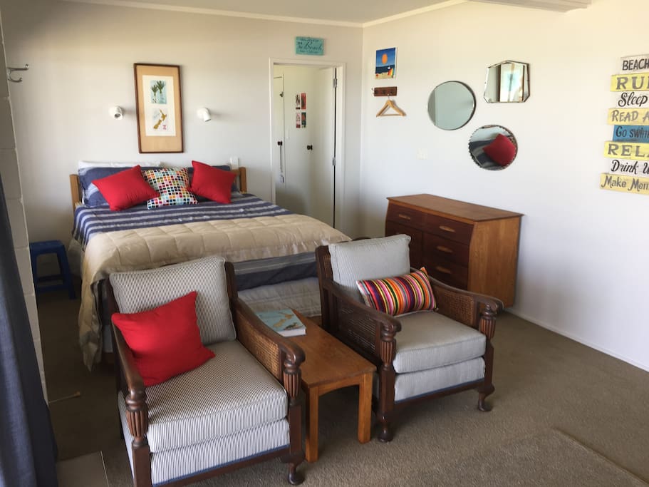 The living area and queen bed with the door to the bedroom on the right-side of the bed..