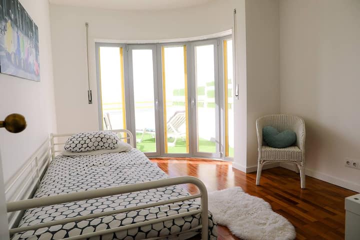 Bedroom 4 with doors and windows leading to the front terrace with ocean views.