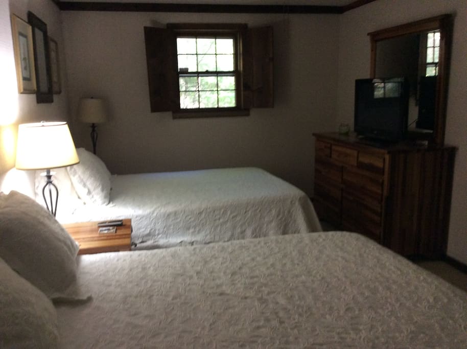 Downstairs bedroom with two queen beds and large tv