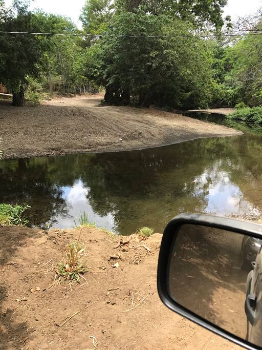 La propiedad tiene 3 vías de acceso, en 2 de ellas se debe pasar por un río (uno prácticamente seco durante casi todo el año, y el otro, el de la foto, tiene un nivel de agua como el que se muestra). La tercera vía es una trocha la cual se utiliza en caso de que ambos ríos tengan un nivel elevado de agua durante la época lluviosa)