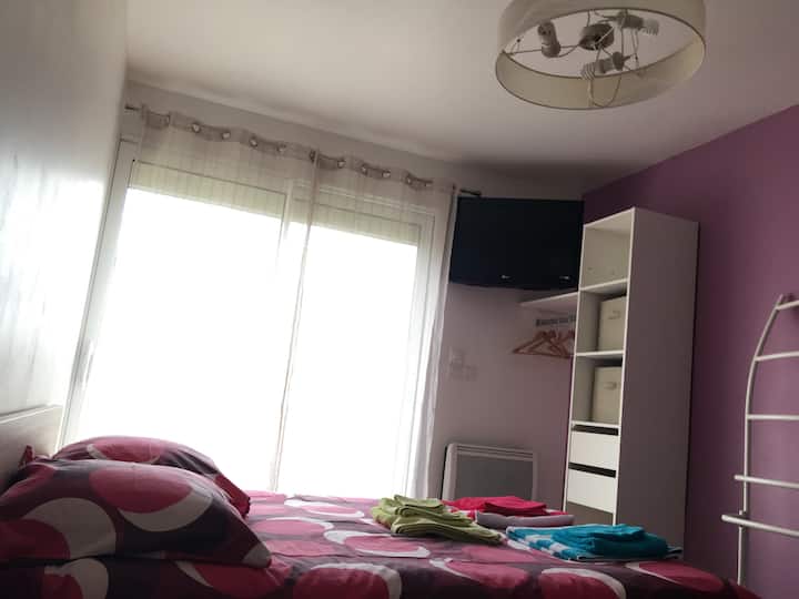 Spavaća soba na katu s balkonom, TV-om i prostorom za odlaganje. 