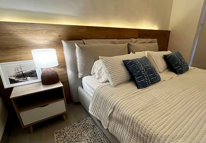 Recámara principal con colchón KING, walk-in closet, baño en suite y TV 65”. Con panel de madera parqué e iluminación led cálida para una atmóstera super comfy!