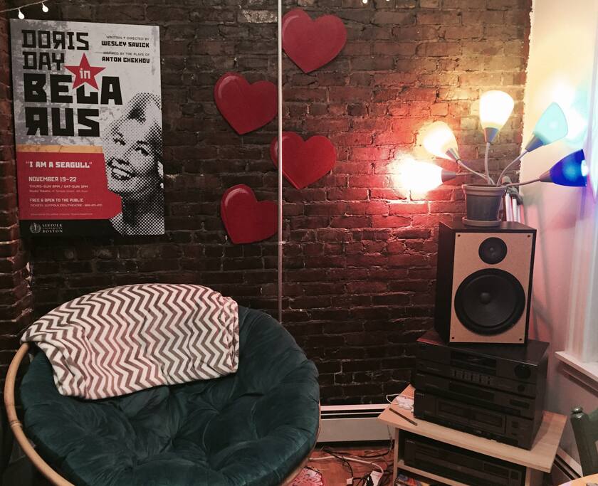 Comfy corner where I like to read and listen to music, a lot of my apartment is decorated with posters from theatre shows I've participated in.