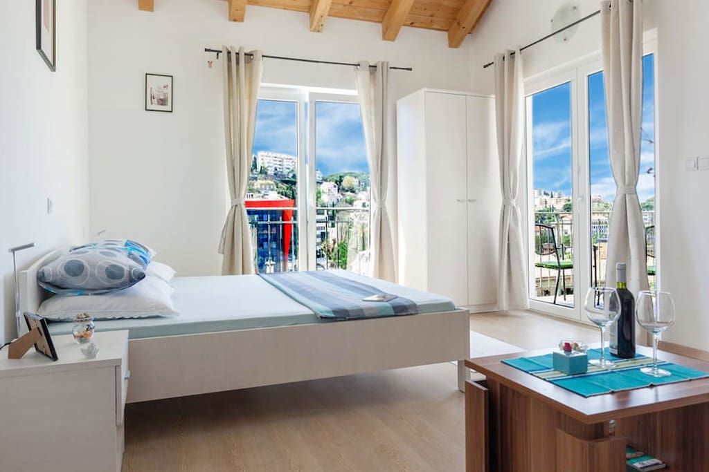 One bedroom with high lighty windows and exit to the balcony