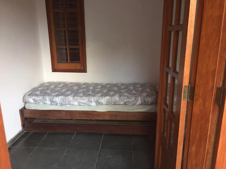 طابق علوي في مسكن مع سريرين فرديين هما سرير متحرك ومراتب مزدوجة.