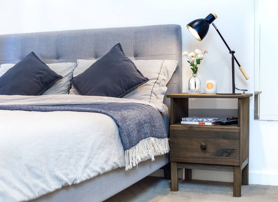 Relaxing Queen Size memory foam mattress, plush bedding with side table and full length wall mirror.