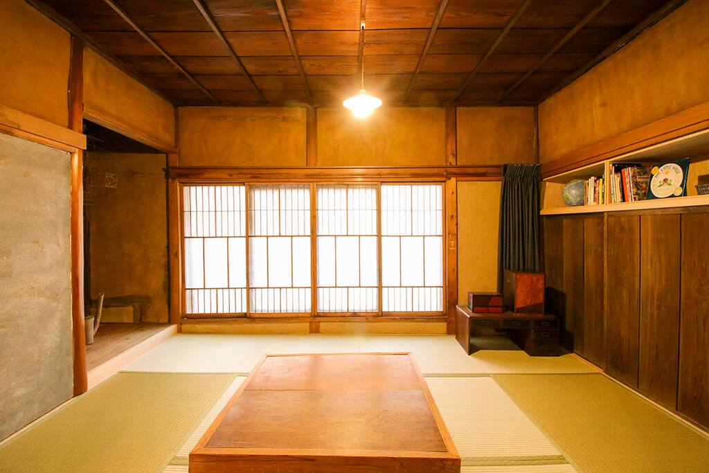 The living room has tatami, original dirt walls and windows, a traditional heated kotatsu table and two futon that may be used for additional guests