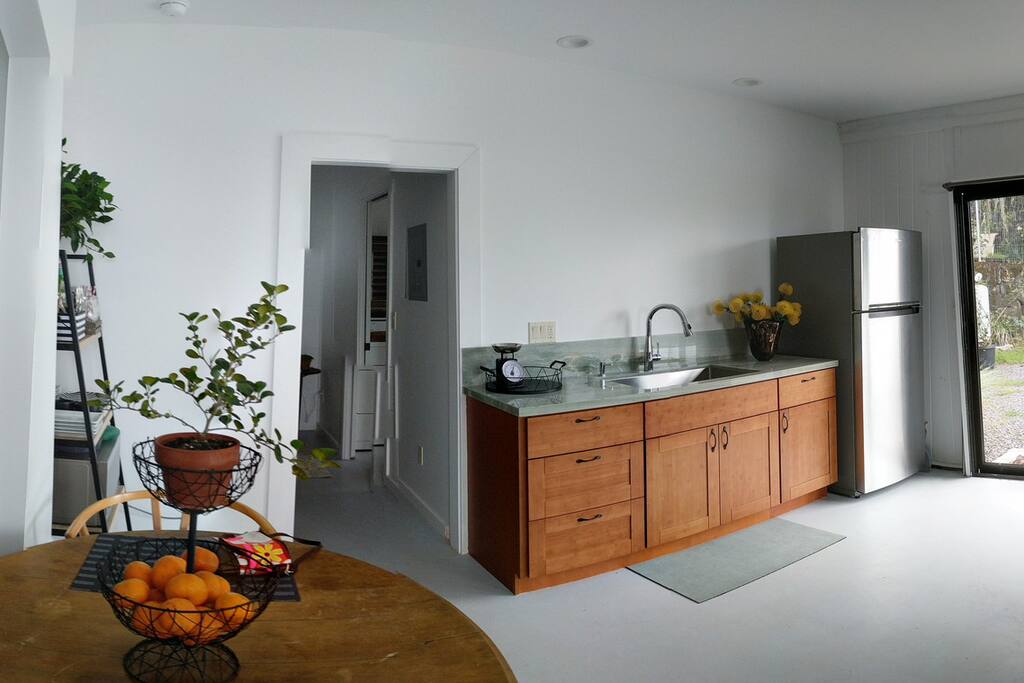 Kitchen with farm sink, freezer, fridge, dishes, and utensils.