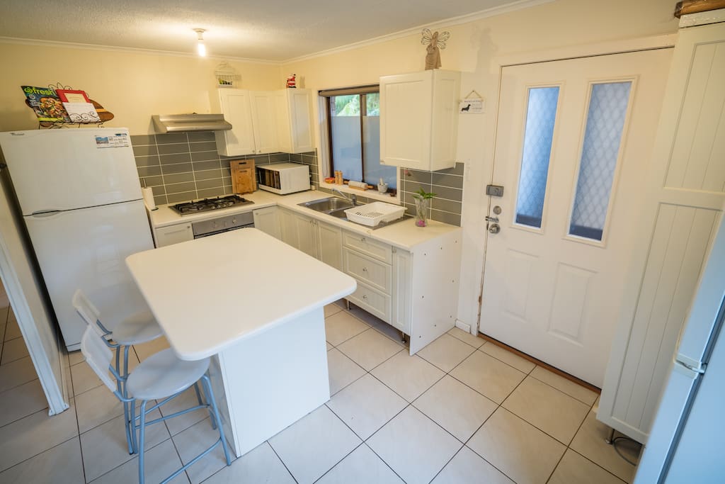 Kitchen featuring twin sink, oven, cooktop, fridge/freezer and cupboards