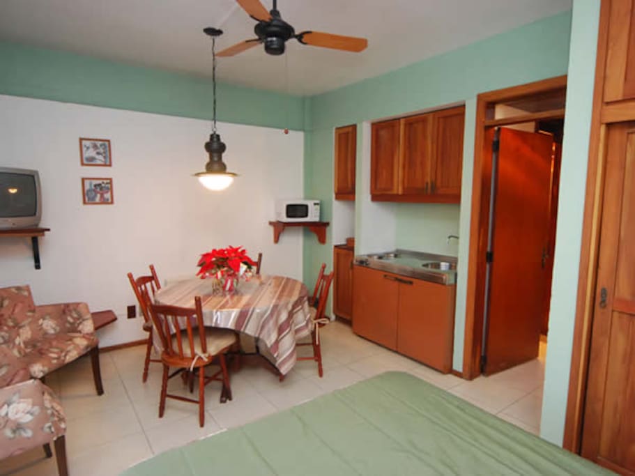 Quarto completo com cama de casal e cozinha compacta