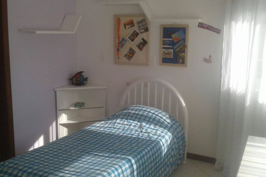 Quarto iluminado, de frente para rua tranquila.
