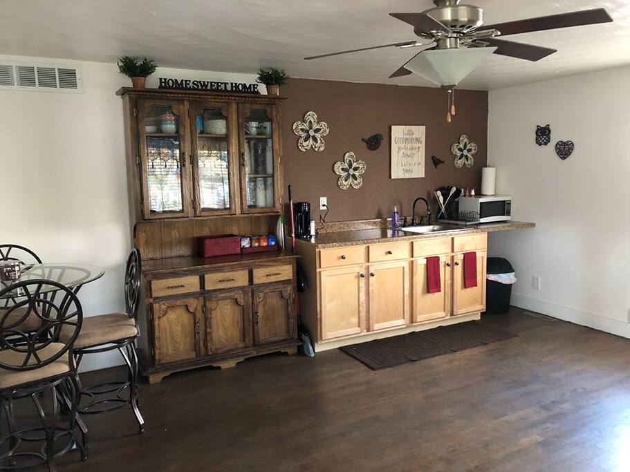 Kitchenette with electric skillet, paper plates & bowls, silverware, kureg, coffee, creamers, & snacks.