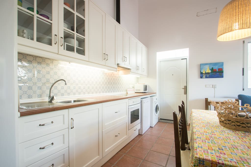 Cocina con Frigorifico, Horno, Vitroceramica, Lavavajillas, Lavadora, Congelador y Microondas.