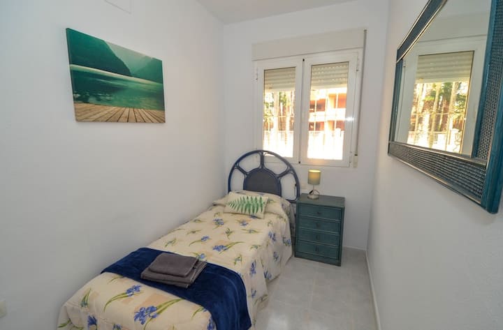 This single bedroom is large, it has a hanging rail with shelves, there is also a standing fan for your comfort.