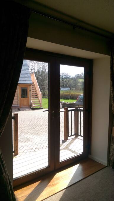 French doors to decking. River on other side of hedge