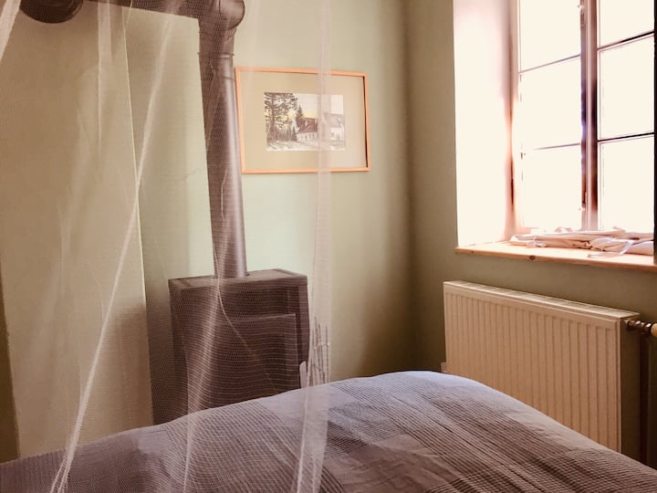 Schlafzimmer mit Holzofen vor dem Bett