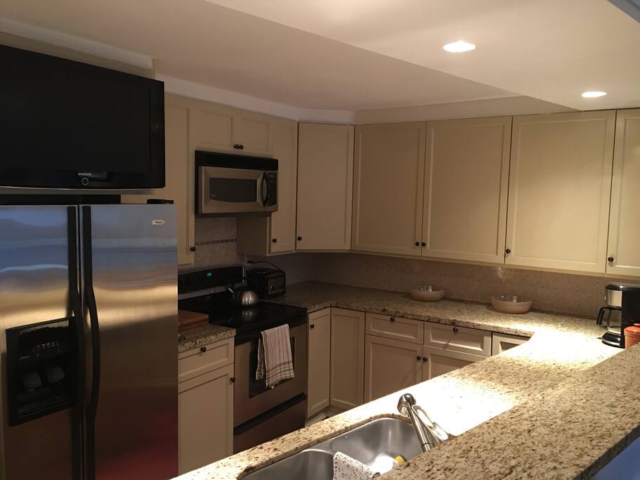 Open concept kitchen, stocked with spices, coffee, a variety of teas, some condiments