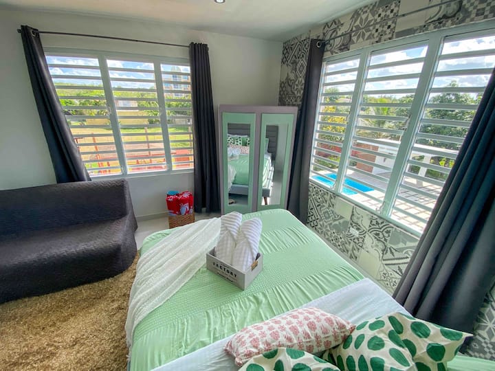 Master bedroom has a view of the wooden deck and pool area