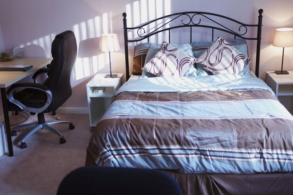 Full-size bed with laptop workspace and office chair
