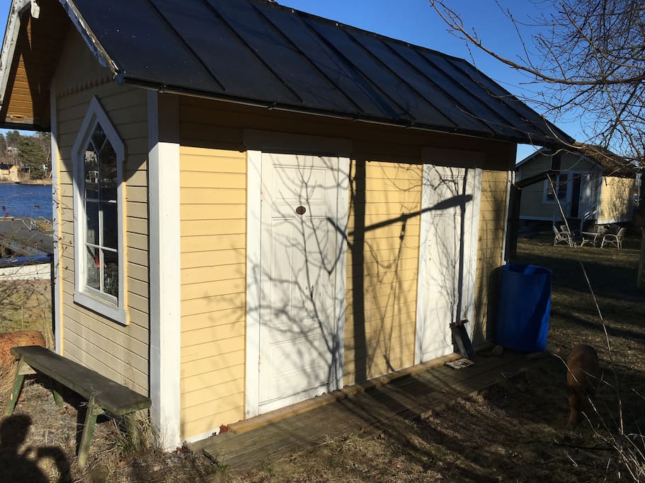 Sauna back-side with intrance, left door. Cottage in background.