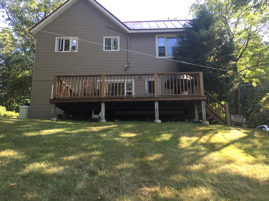 Back deck and yard slopes down to stream