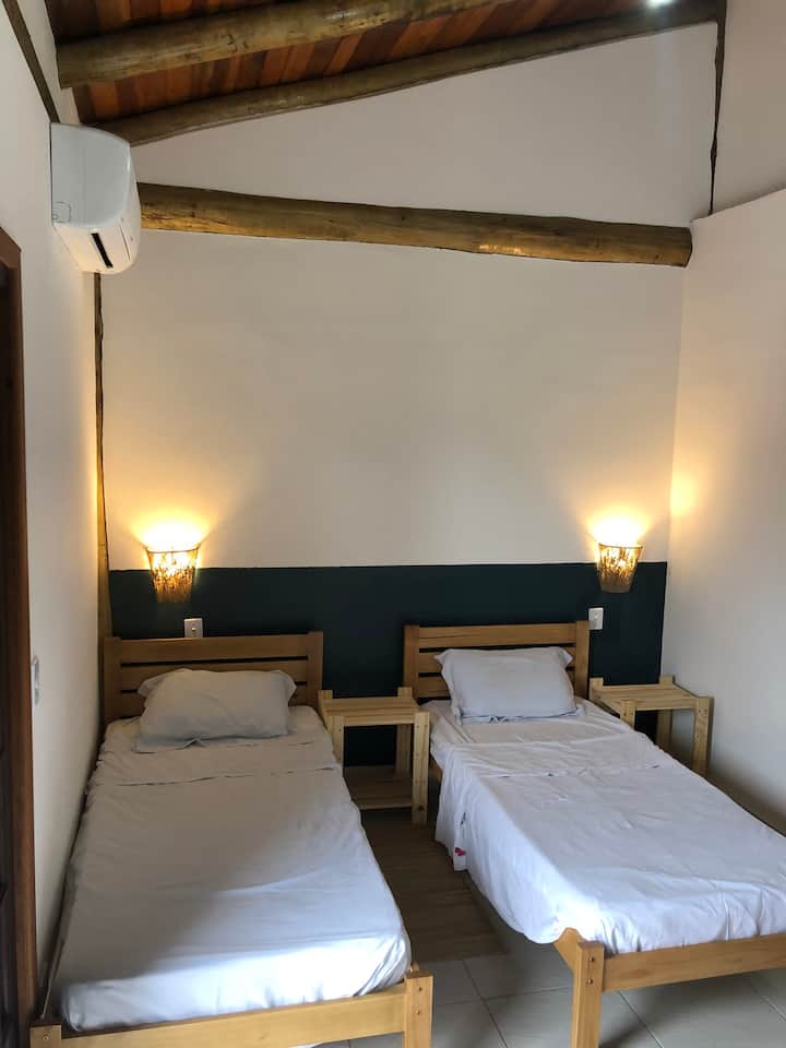 Suite med aircondition, 2 enkeltsenge, sconces med hyggelig belysning og 2 sengeborde til støtte.