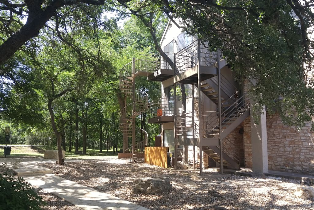 My building is surrounded by trees with a large grassy area in the back. A private spiral staircase serves as a back entrance to the patio.