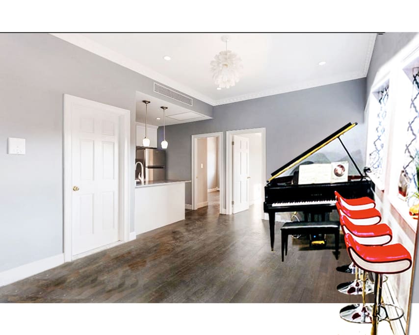 Gorgeous living room, with grand pianos, bar stools, sofa bed and all.