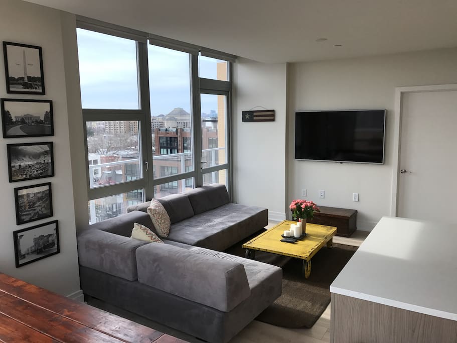 Well appointed living room with comfortable sectional sofa, flatscreen TV, and large custom made dining table