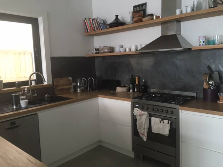 Modern kitchen. Gas cooking with dishwasher and bar fridge.