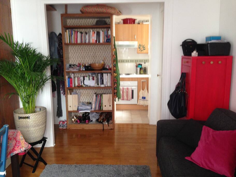 Autre partie du salon avec accès à la cuisine et toilettes sur la droite.