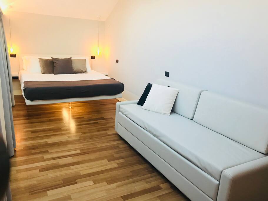 Camera con letto sospeso e divano letto