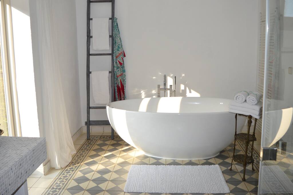 Großes Badezimmer mit bodentiefem Fenster.