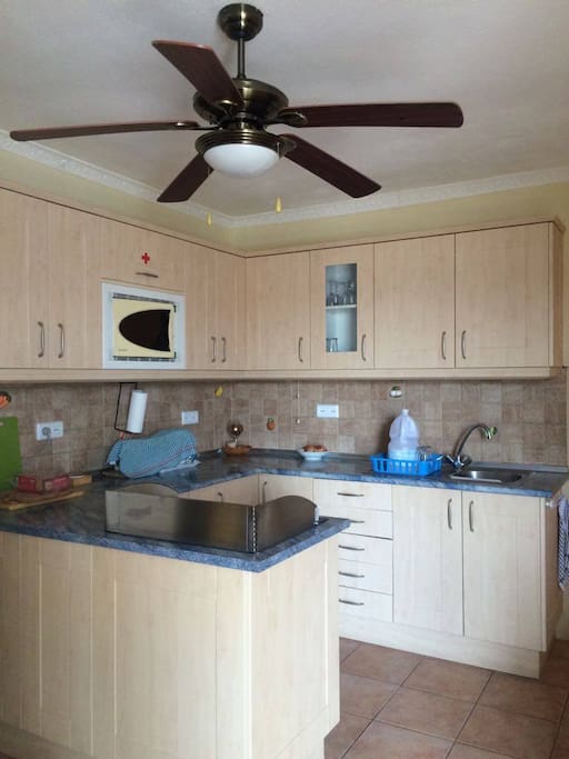 Kitchen with cooker, hob, sink, microwave and utensils