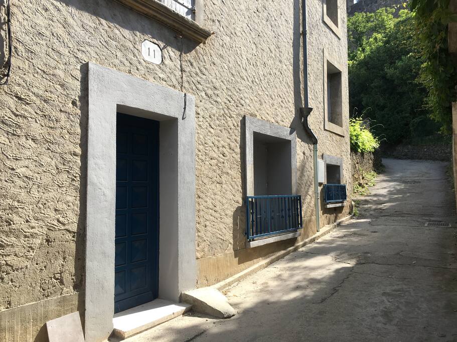 Côté remparts , la façade de la maison et le début du sentier pour aller à la cité